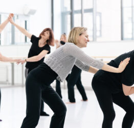 Four older dancers exploring movement through contact.